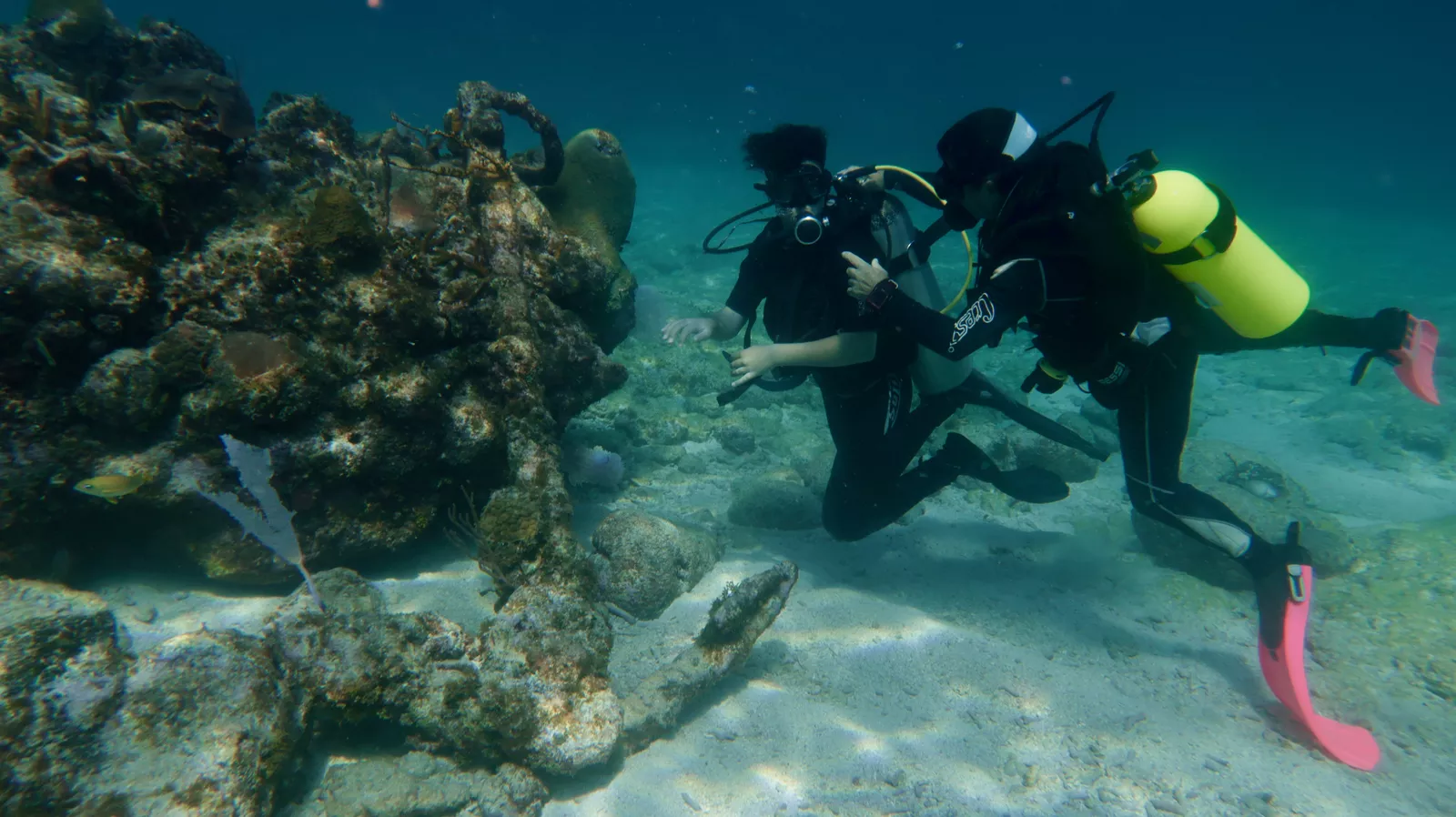 PADI instructor assisting student underwater during scuba course