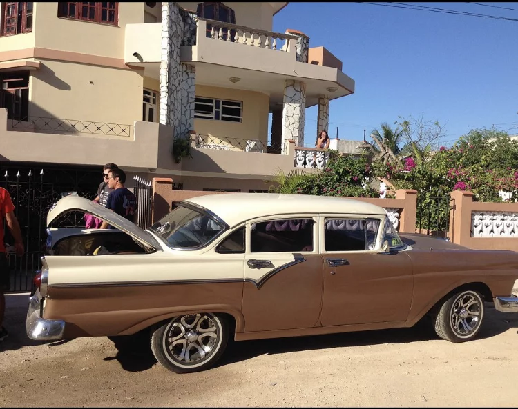 Classic car piking up diver at private B&B for a scuba diving trip